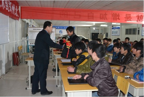 校长刘振华在开班仪式上为北方新学员发放北方校服.jpg